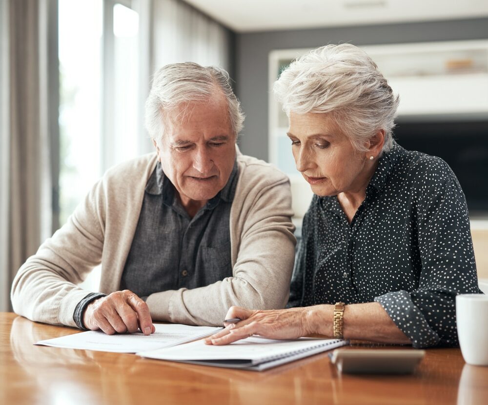 senior couple sitting together and going through their finances at home